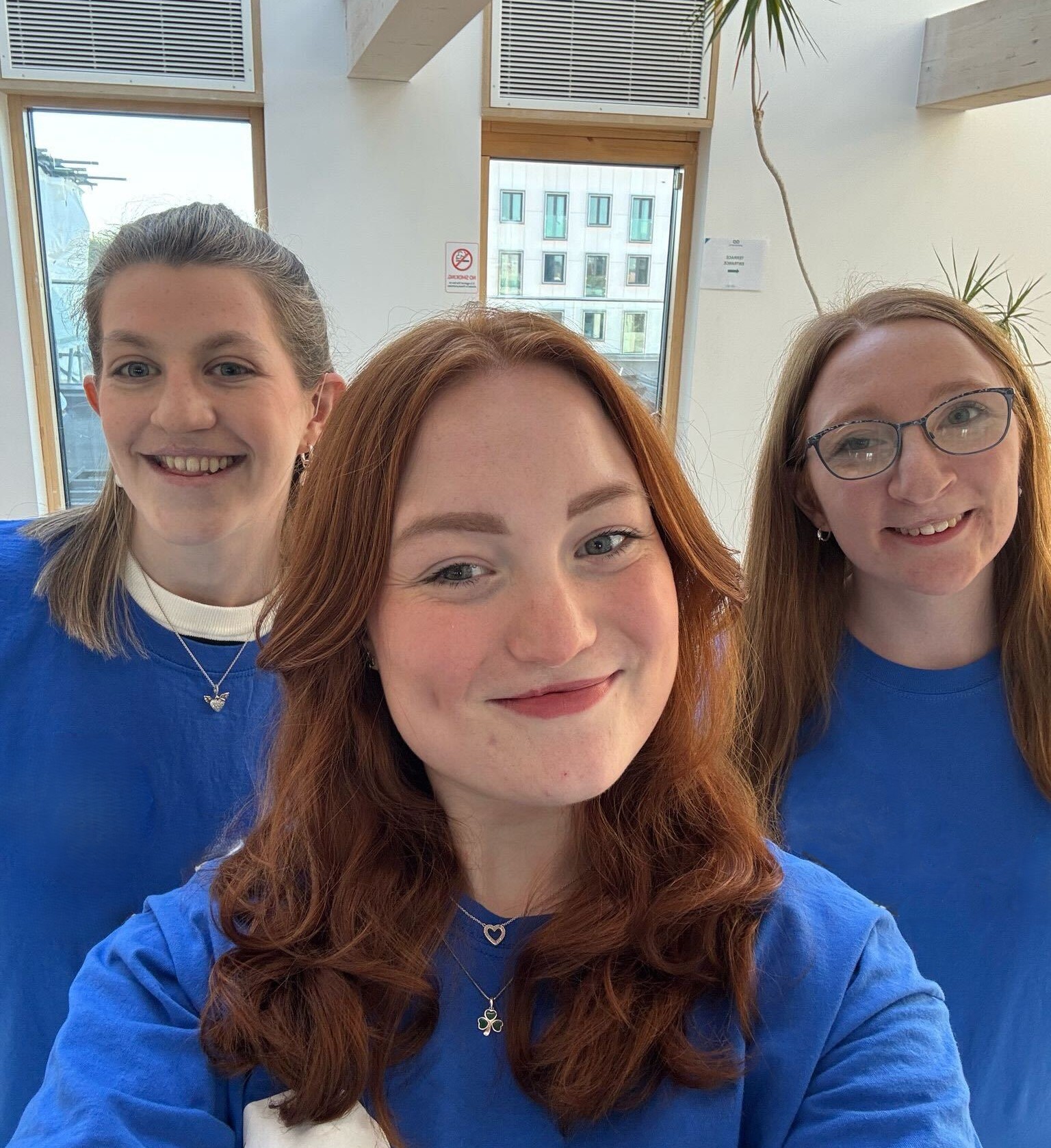 Three young CLAPA volunteers smile at the camera